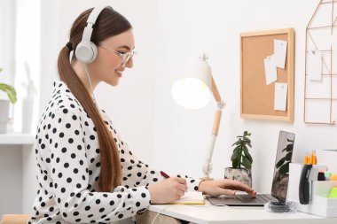 E-öğrenme. İçerideki masada ders alan bir kadın.
