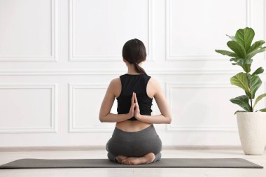 Yoga stüdyosunda arkasında namaste ile vajinanı prova eden bir kız.