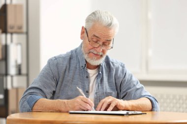 Son sınıf öğrencisi içeride masada son arzusunu ve vasiyetini imzalıyor.