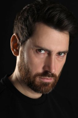 Kem göz. Siyah arka planda korkunç gözleri olan adam, yakın plan.