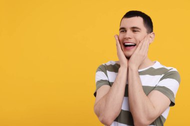 Turuncu arka planda şaşırmış bir adamın portresi, metin için boşluk