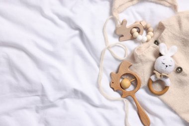 Beyaz kumaşta farklı bebek aksesuarları, üst manzara. Metin için boşluk