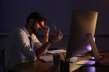 Geç saatlere kadar çalışan yorgun genç adam.