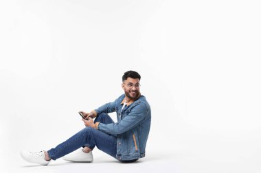 Beyaz arkaplanda akıllı telefon kullanan yakışıklı adam, metin için boşluk