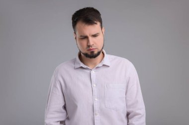 Gri arka planda üzgün bir adamın portresi