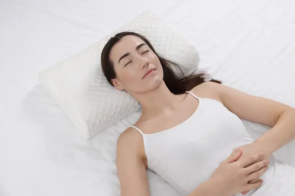 Woman sleeping on orthopedic pillow in bed