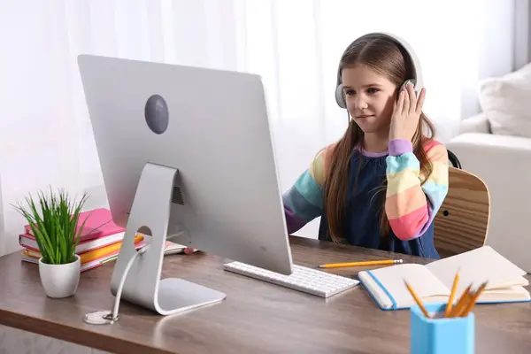 Learning Roztomilé Dívka Pomocí Počítače Sluchátka Během Line Lekce Stolu — Stock fotografie
