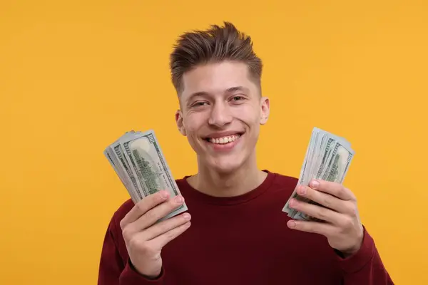 stock image Happy man with dollar banknotes on yellow background