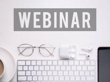 Giyin. Bilgisayar klavyesi, kulaklıklar, gözlükler ve akıllı telefon beyaz masada, düz konum