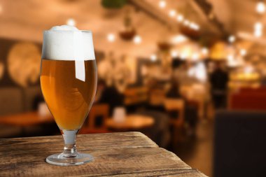 Bardaki ahşap masada taze bira, mesaj için yer var.