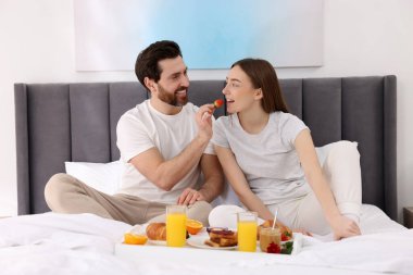 Sağlıklı kahvaltı. Mutlu koca, karısını evde besliyor.