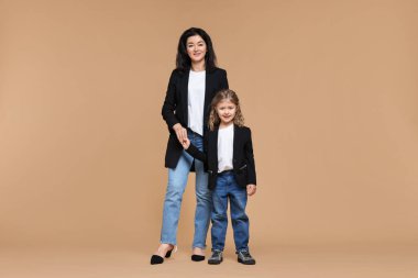 Bej arka planda küçük kızı olan güzel bir anne.