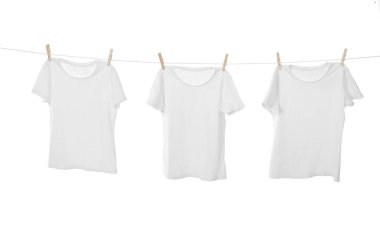 Çamaşır ipinde kuruyan birçok tişört beyaza izole edilmiş.