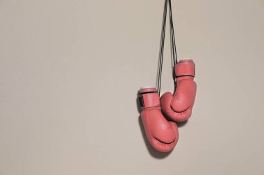 Göğüs kanserine karşı savaş. Gri arkaplanda bir çift pembe boks eldiveni, metin için boşluk