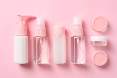 Pembe arka planda kozmetik seyahat seti, düz yatış. Banyo aksesuarları