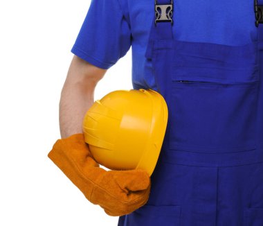 Beyaz arka planda sarı başlıklı genç adam, yakın plan. Güvenlik ekipmanları