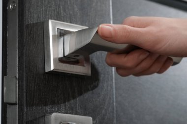 Kapıda ahşap kapı açan kadın, kapı koluna yakın çekim.