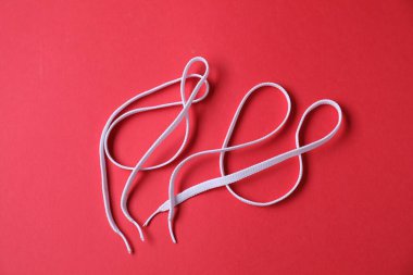 Kırmızı zemin üzerinde beyaz ayakkabı bağcıkları, üst görünüm