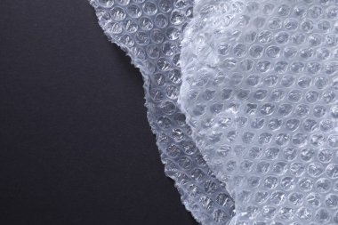 Siyah arkaplanda şeffaf baloncuk ambalajı, üst görünüm. Metin için boşluk