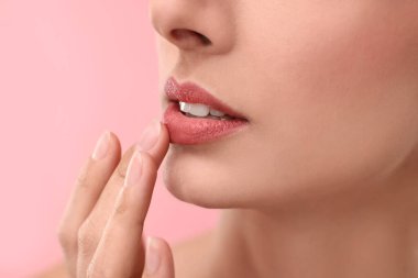 Pembe arka planda güzel dudakları olan kadın, yakın plan.