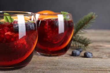 Aromatik Noel Sangria kadehleri ahşap masada, yakın plan.