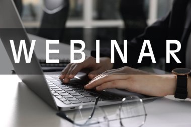 Çevrimiçi webinar. Beyaz masada dizüstü bilgisayar kullanan kadın, yakın plan.