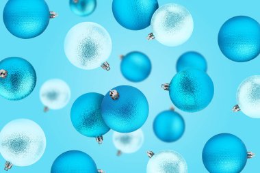 Açık mavi Noel topları renk arkaplanına düşüyor