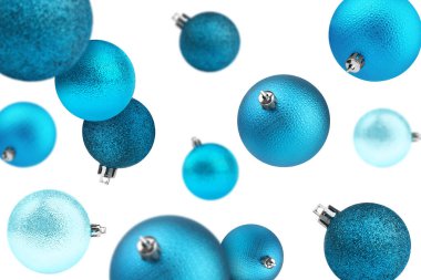 Açık mavi Noel topları beyaz arka plana düşüyor