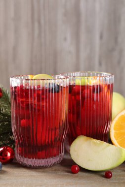 Bardaklarda, malzemelerde ve Noel dekorunda ahşap masada Aromatik Sangria içeceği.