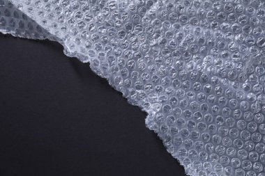 Siyah arkaplanda şeffaf baloncuk ambalajı, üst görünüm. Metin için boşluk