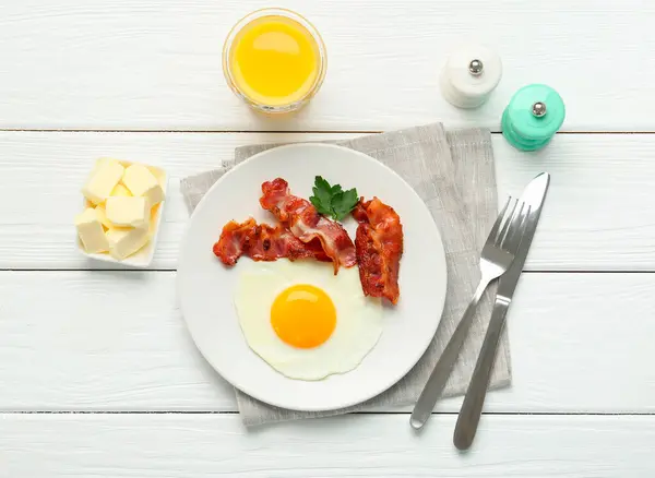 Delicious breakfast with sunny side up egg served on white wooden table, flat lay