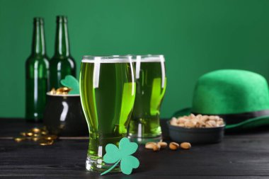 St. Patrick 'in gündüz partisi. Yeşil bira, leprikon şapka, bir küp altın, şam fıstığı ve ahşap masa üzerindeki dekoratif yonca yaprağı.