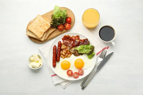 Delicious breakfast with sunny side up eggs served on white table, flat lay