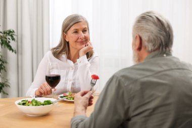 Mutlu son sınıf çifti evde romantik bir akşam yemeği yiyor.