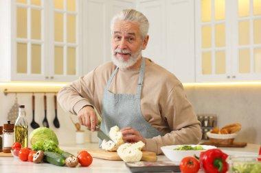 Mutfakta karnabahar kesen mutlu adam.