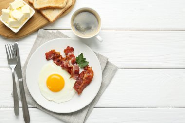 Beyaz ahşap masada servis edilen güneşli kenarlı yumurtalı nefis bir kahvaltı. Metin için boşluk