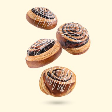 Tatlı çörekler. Bej arkaplana düşen haşhaş tohumlu lezzetli börekler.