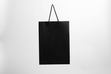 Gri arkaplanda bir siyah kağıt alışveriş çantası