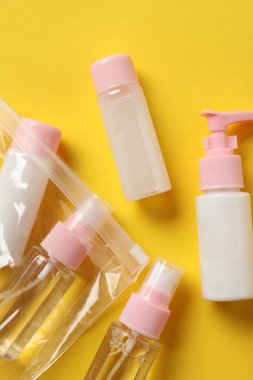 Sarı zemin üzerinde kozmetik seyahat seti olan plastik torba, düz. Banyo aksesuarları