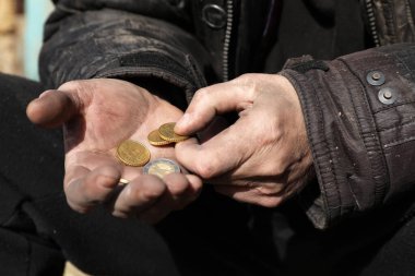 Dışarıda bozuk para tutan zavallı evsiz adam, yakın plan.
