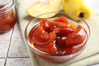 Lezzetli ev yapımı ayva reçeli kasede ve meyveli masa, yakın plan.