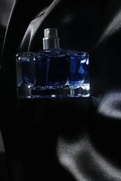 豪华男子香水在瓶子上的黑色缎子面料 顶部视图 案文的篇幅 — 图库照片