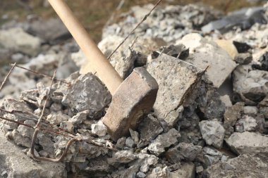 Kırık taş yığınının üzerinde balyoz, yakın plan.