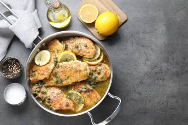 Gri masa üzerinde nefis tavuk piccata, düz yatıyordu. Metin için boşluk