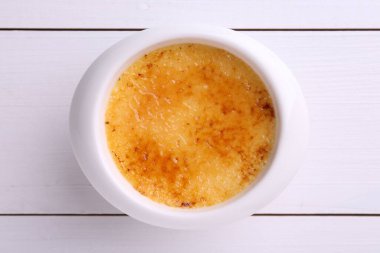 Lezzetli creme brulee kasede beyaz ahşap masa, üst manzara