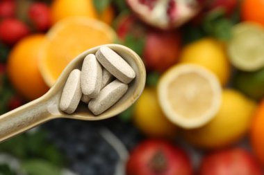 Kaşıkta vitamin hapları, taze meyveler, üst manzara. Metin için boşluk