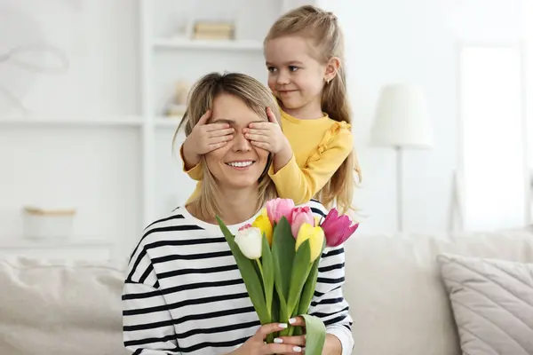 Klein Meisje Verrast Haar Moeder Met Een Boeket Tulpen Thuis — Stockfoto