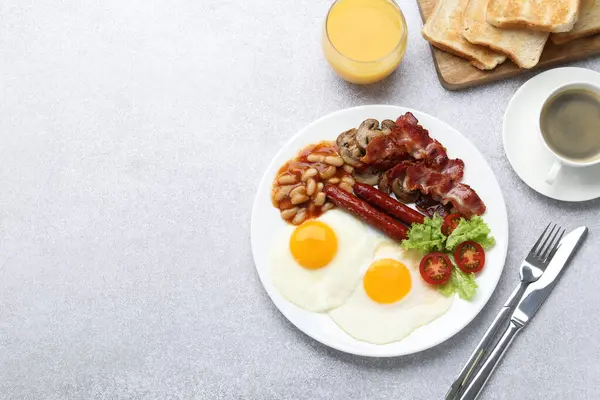 Delicious breakfast with sunny side up eggs on light table, flat lay. Space for text