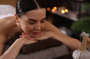Spa terapisi. Salondaki masaj masasında uzanmış güzel genç bir kadın.