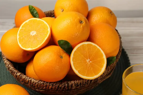Many ripe juicy oranges on white wooden table, closeup